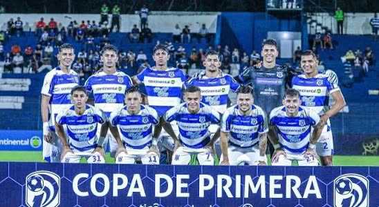 Elenco do 2 de Mayo posado para foto oficial em campo, de uniforme listrado azul e branco, com a faixa da Copa de Primera à frente.