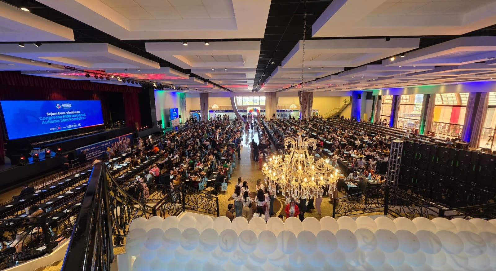 Salón de eventos lleno durante el Congreso Internacional Autismo Sin Frontera, con pantalla de bienvenida al fondo