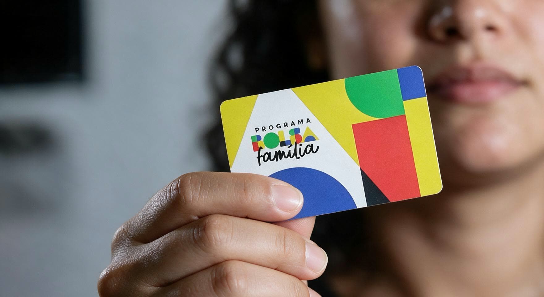 Mão segurando o cartão do Programa Bolsa Família