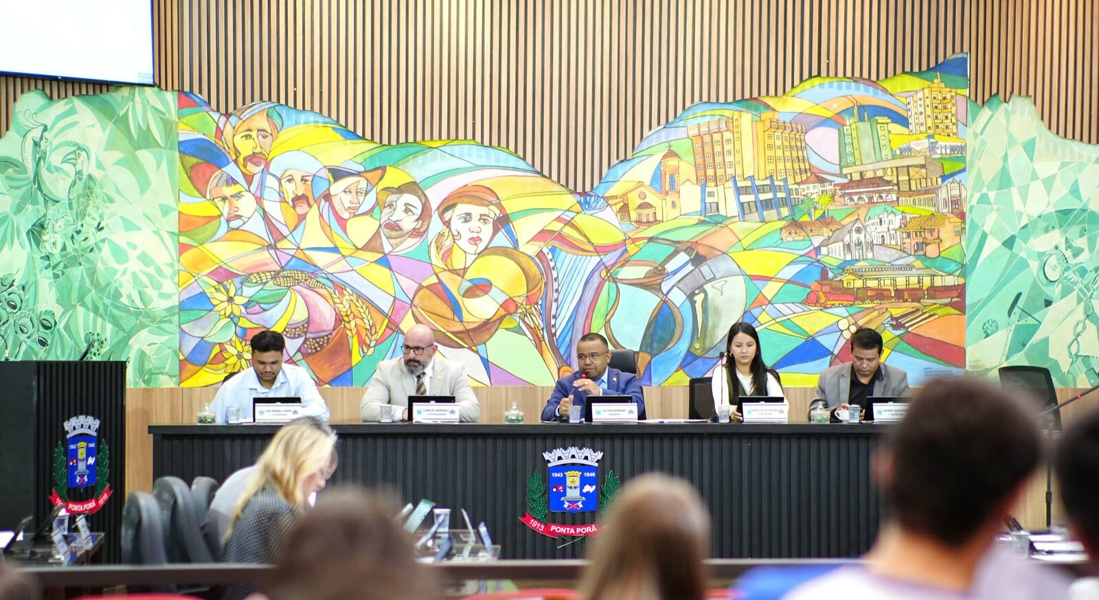 Mesa diretora da Câmara de Ponta Porã em sessão, com estudantes assistindo nas cadeiras do plenário