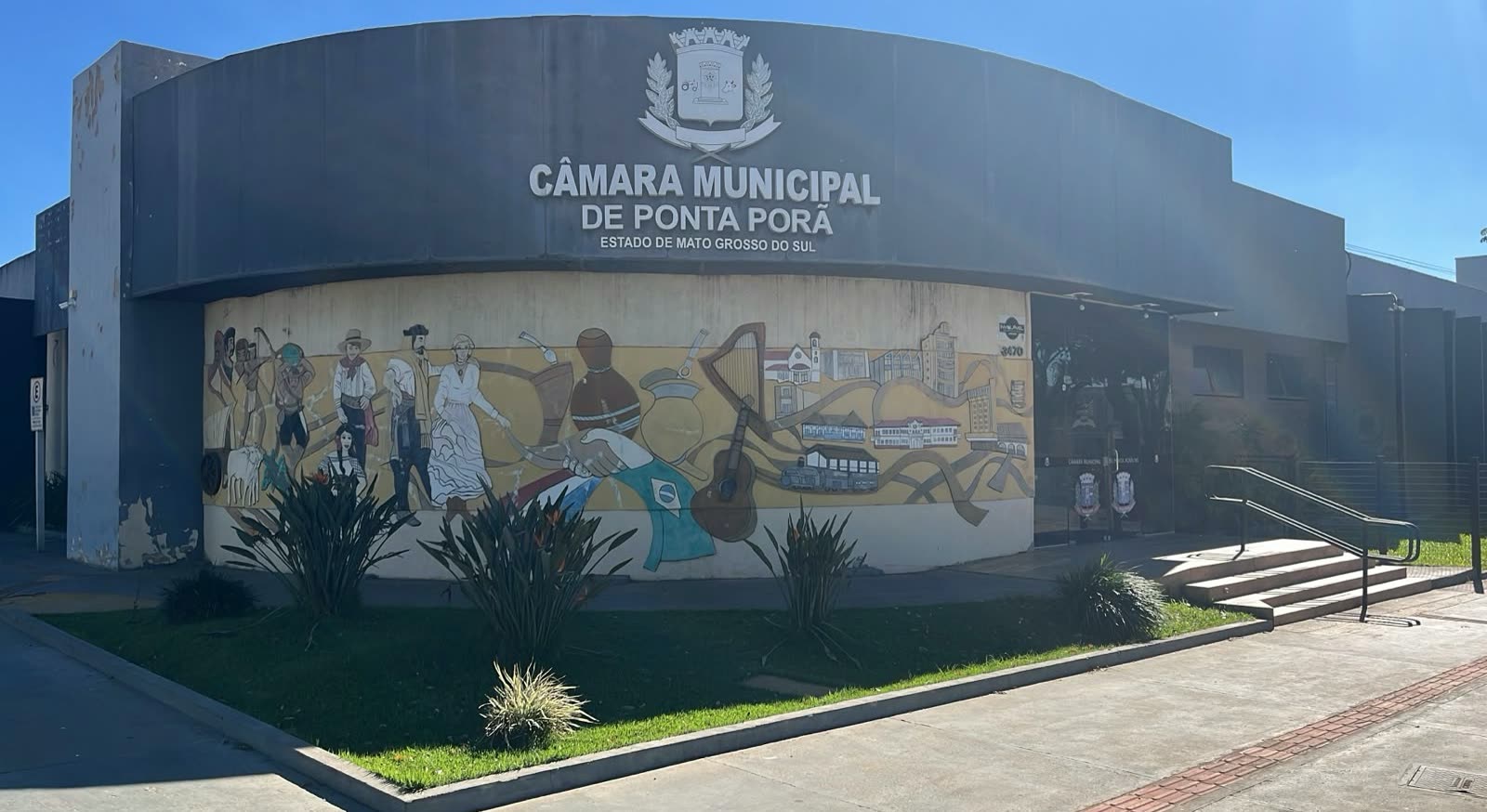 Fachada da Câmara Municipal de Ponta Porã, com painel pintado retratando cenas da história da cidade
