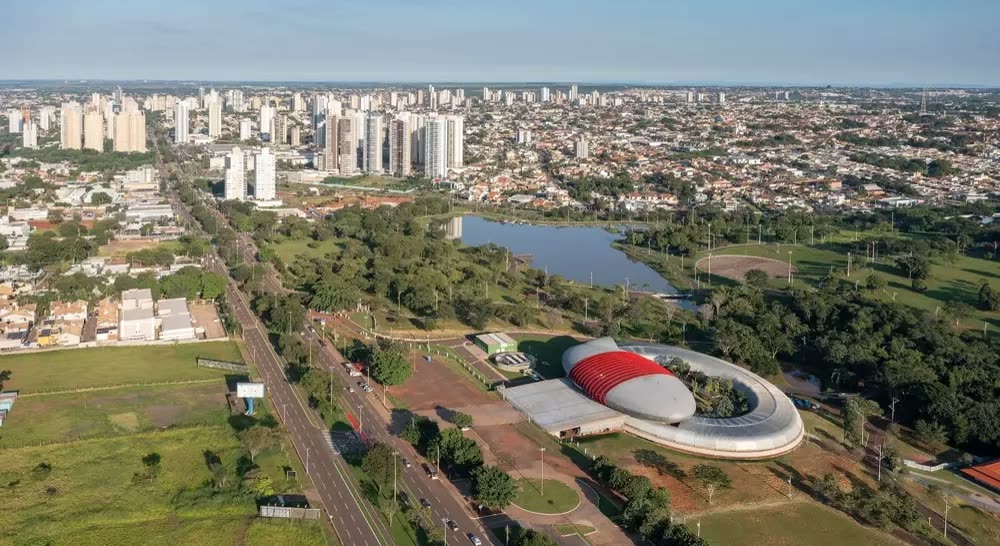 Vista aérea de Campo Grande, com avenida, lago e prédios ao fundo
