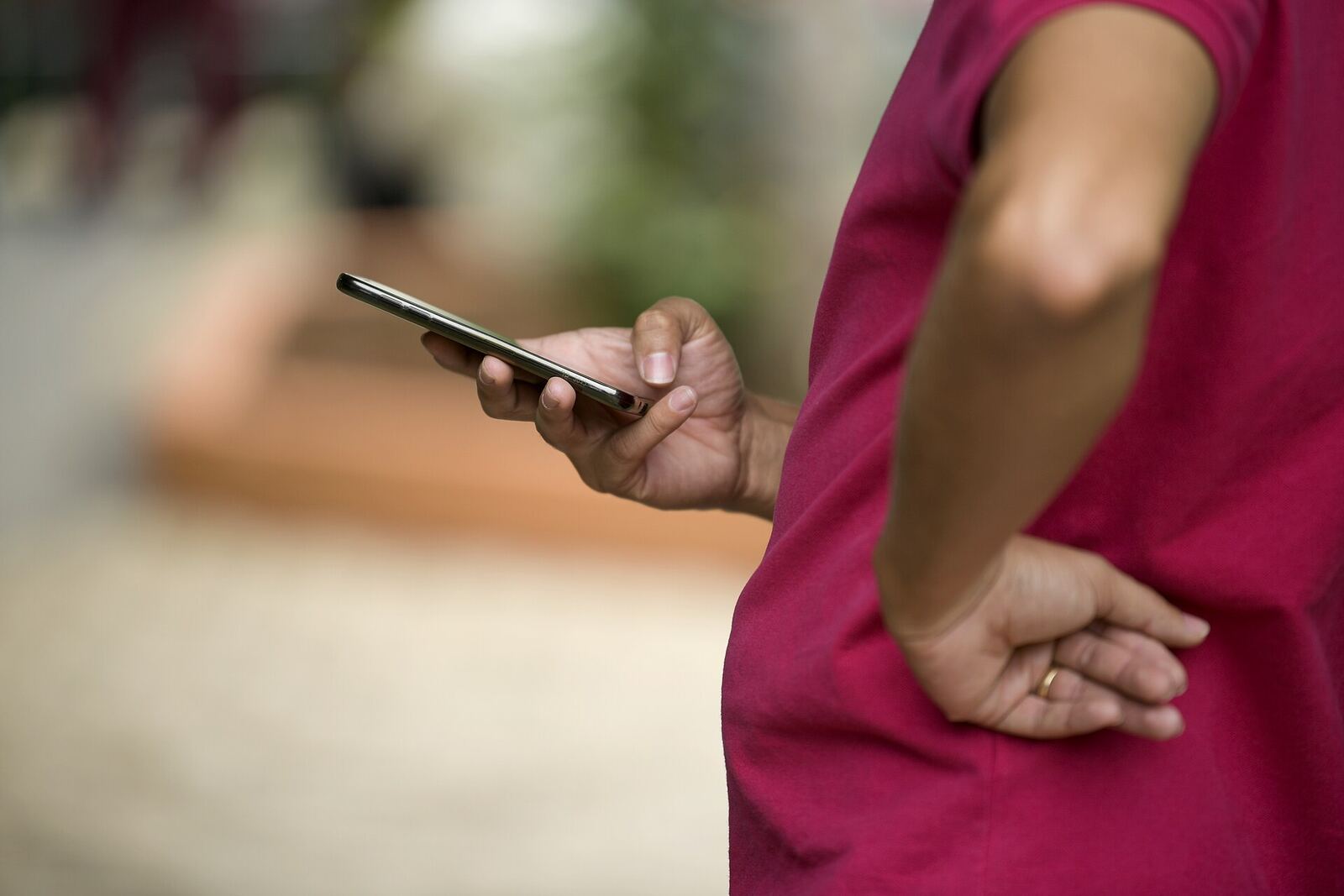 Elector de remera roja sostiene el celular con una mano, con la otra apoyada en la cintura