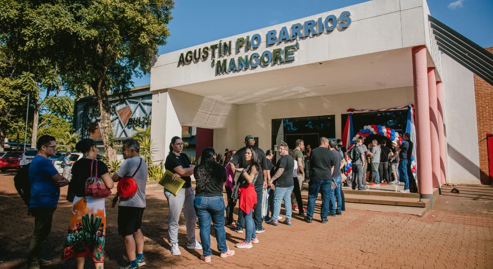 Fila de pessoas em frente a um prédio público durante um atendimento do MigraMóvil
