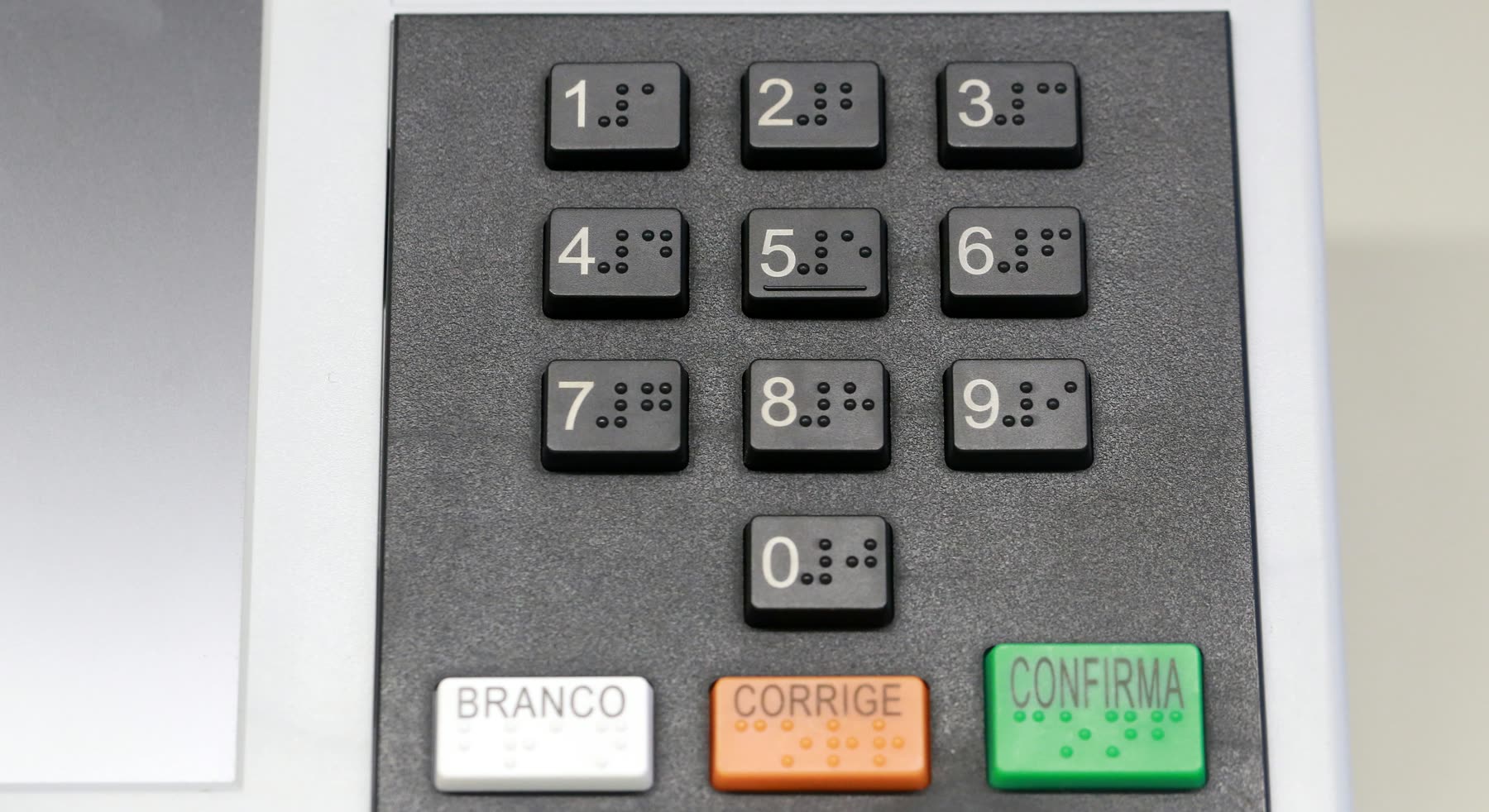 Teclado en braille de la urna electrónica, con los botones blanco, corrige y confirma, y el sello Justicia Electoral
