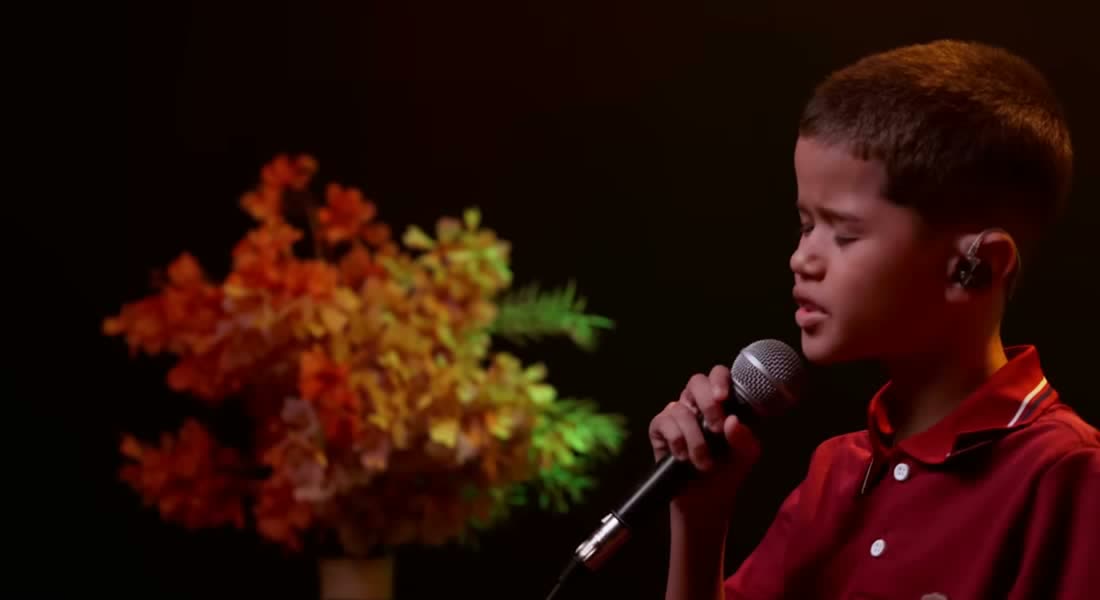 Rafael Mello, de 12 años, canta “Vou Curar Você” frente al micrófono en una grabación de estudio.