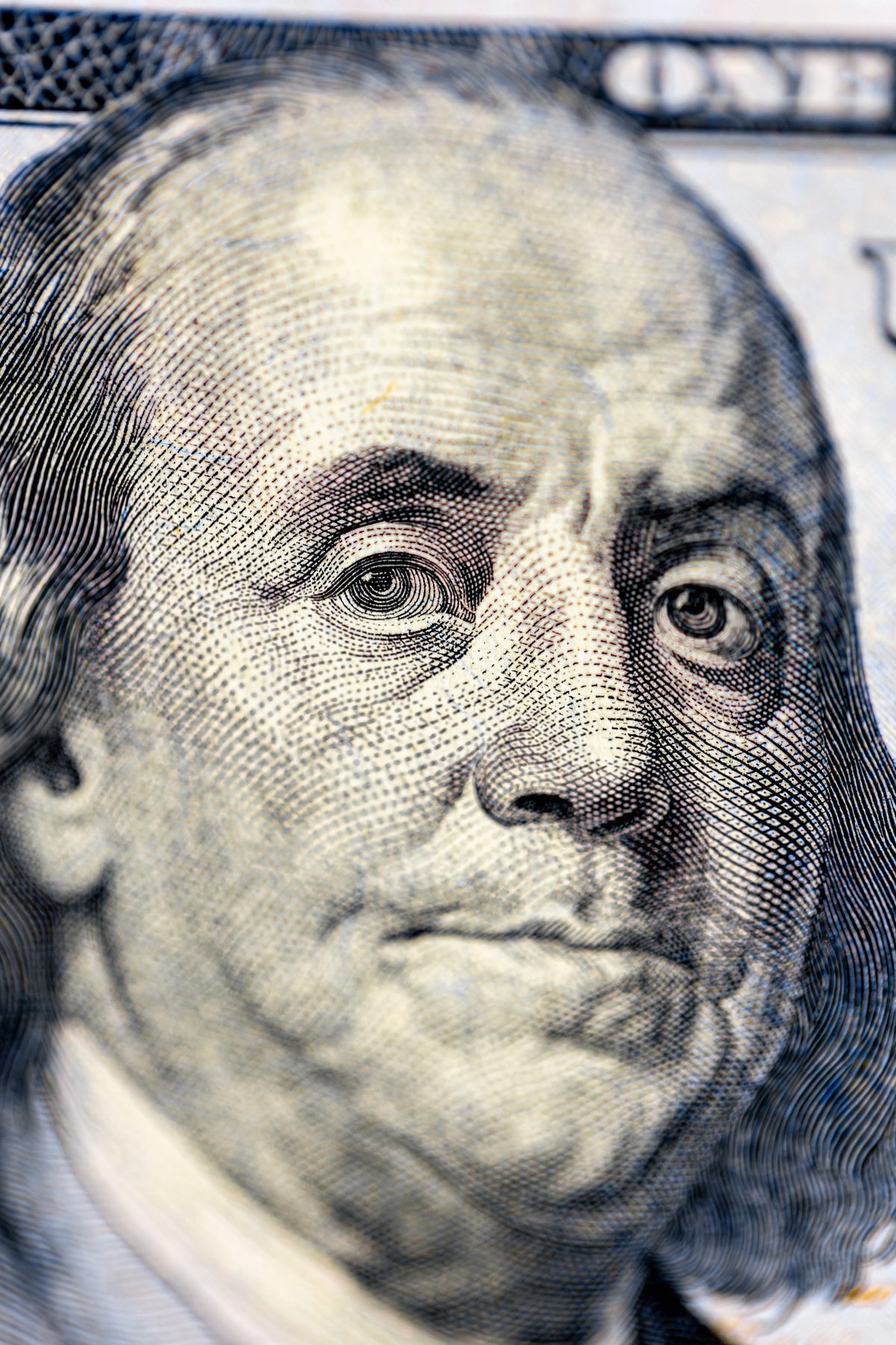 Detalhe aproximado do retrato de Benjamin Franklin numa nota de cem dólares