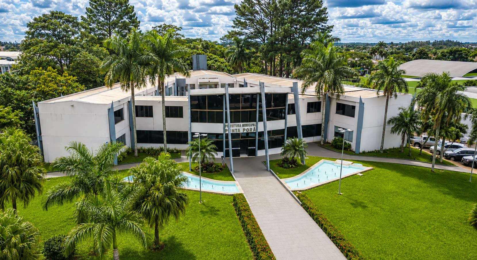 Vista aérea del edificio de la Municipalidad de Ponta Porã, con jardín y espejos de agua en la entrada