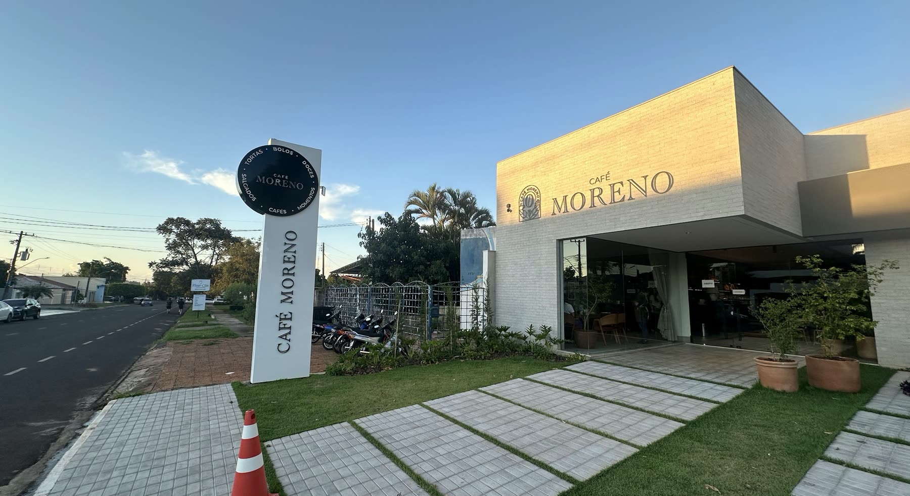 Edificio blanco con el letrero Café Moreno en la fachada y un tótem alto con el mismo nombre al borde de la calle