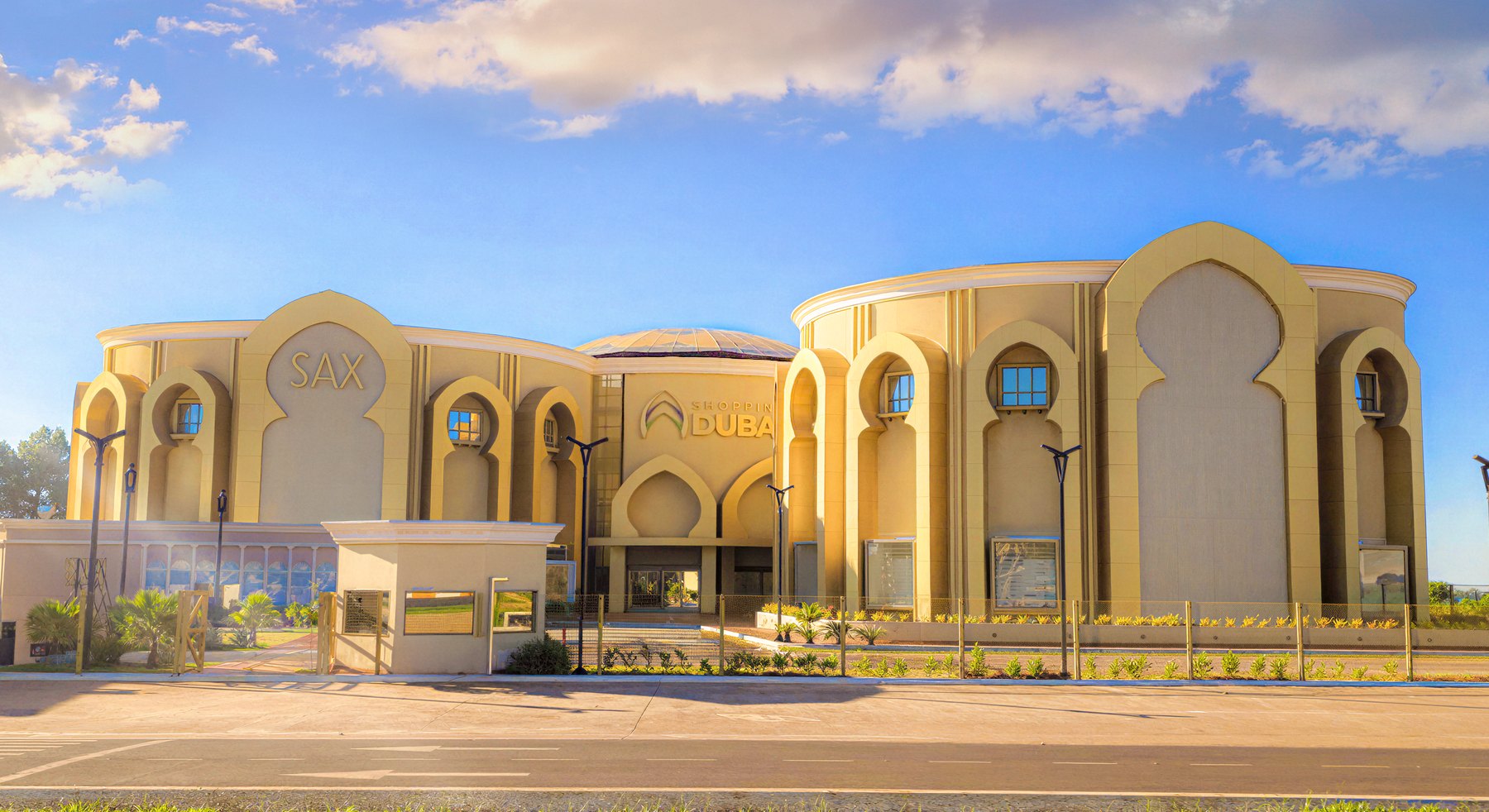 Edificio beige con torres redondeadas, cúpulas y ventanas en arco, con el letrero Dubai sobre la entrada